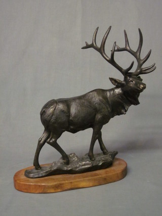 A bronzed figure in the form of a standing Stag, raised on an  oval wooden base 20"