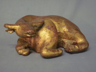 An Eastern carved and gilt painted figure of a seated buffalo 17"