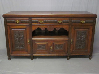 An Edwardian carved walnut sideboard fitted 1 long drawer  above a recess with cupboard below flanked by a pair of drawers  with cupboard below, raised on turned feet 71"