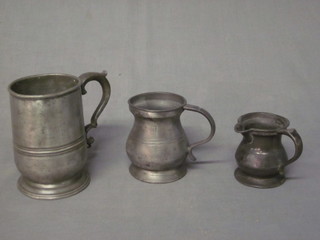 A pewter pint tankard, a pewter baluster shaped measure and a  spouted measure