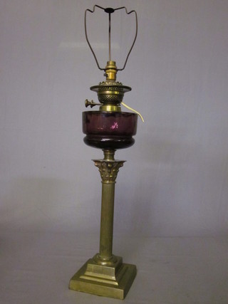 A Victorian amethyst glass oil lamp reservoir raised on a reeded brass column with Corinthian capital ILLUSTRATED
