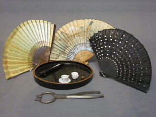 A circular black lacquered tray, a pair of steel sugar nips, 3 fans  etc