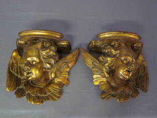 A pair of gilt wall light brackets in the form of cherubs heads 12"