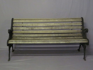 A Victorian style wooden slatted garden bench with pierced  aluminium supports 61"