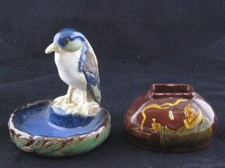 A Doulton Burslem ashtray decorated a bird, the base marked X8946 6" and an oval match striker decorated a gentleman  wearing a ruff base marked Royal Doulton 4 1/2", chipped,  PART ILLUSTRATED