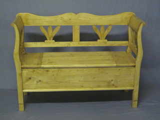 A Continental stripped and polished pine settle with hinged lid  48"