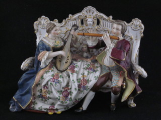 A Continental porcelain figure group of seated lady and  gentleman musicians, the base with orb mark, gentleman's sword  f and chip to coat, 6"