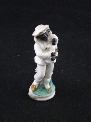 A 19th Century porcelain figure of a standing black clown with  baby 4"