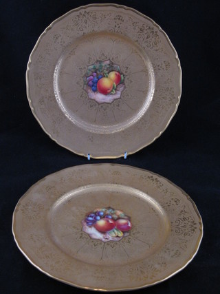A pair of circular Royal Worcester plates with gilt banding,  painted fruit to the centre, one signed O Smith, 11"