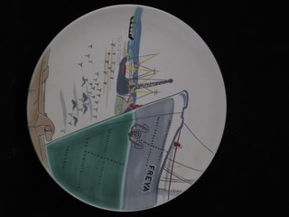 A circular Poole Pottery plate decorated a harbour scene and ship "Freya", etc 12"