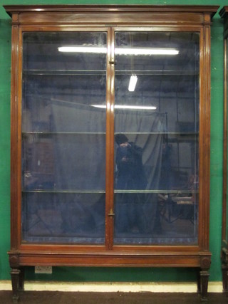 A large and impressive Edwardian mahogany shop display  cabinet the interior fitted shelves enclosed by glazed panelled  doors, raised on square tapering supports 56" x 90"
