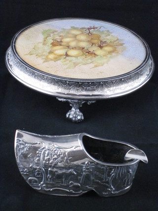 A circular silver plated teapot stand with tile to the centre and a Dutch embossed silver plated ashtray in the form of a clog