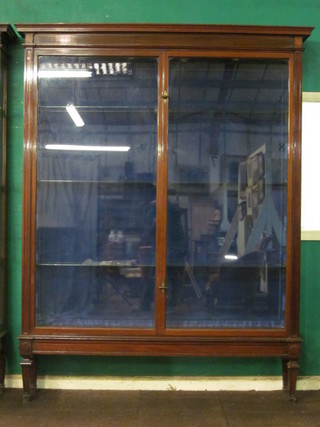 A handsome Edwardian mahogany shop display cabinet, the  interior fitted glazed shelves enclosed by glazed panelled doors  with moulded cornice, raised on square tapering supports, by  Pollard Store Fitters of London, 71" x 90"