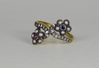 An antique style yellow gold cluster ring set 2 flower heads, set rubies and sapphires supported by diamonds and with pearl petals