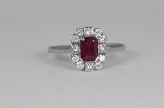 An 18ct white gold dress ring set a rectangular cut ruby  surrounded by diamonds