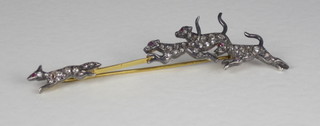 A bar brooch in the form of a fox and hounds, set diamonds and  rubies