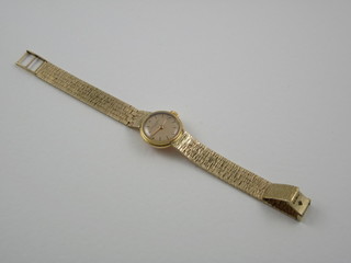 A lady's 1950's Patek Phillipe wristwatch contained in an 18ct gold case with a 9ct gold integral bracelet