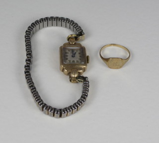 A gold signet ring, a lady's wristwatch contained in a gilt metal  case and a 9ct gold watch back