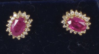 A pair of 18ct gold ear studs set rubies and diamonds