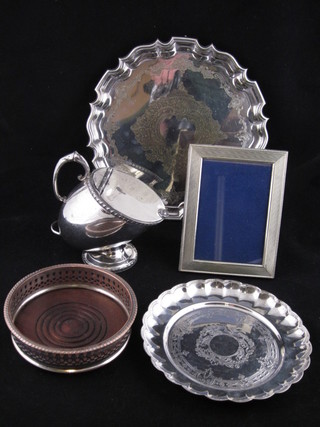 A circular silver plated salver with bracketed border, raised on cabriole feet 10", a silver plated dish, an easel photograph frame,  bottle coaster and a Britannia metal sugar scuttle