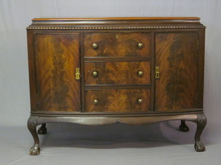 A Chippendale style mahogany bow front sideboard fitted 3 long drawers flanked by double cupboards, raised on cabriole ball and  claw supports, 51"