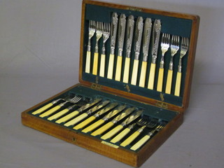 A set of 12 silver plated fish knives and forks contained in an oak  canteen box by Walker & Co