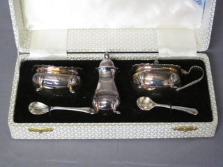 A silver plated 3 piece condiment set with mustard, salt and pepper pot, cased