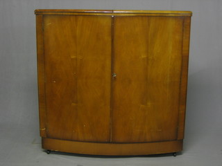 An Art Deco walnut crescent shaped bar enclosed by panelled doors 42"