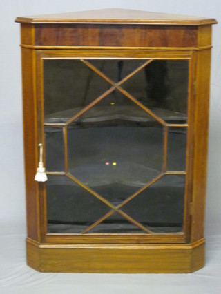 An Edwardian inlaid mahogany corner cabinet, the interior fitted shelves enclosed by an astragal glazed panelled door, raised on  bracket feet 32"