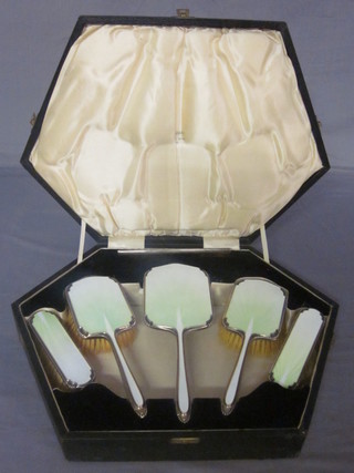 An Art Deco Walker & Hall 5 piece silver and enamel backed  dressing table set comprising pair of clothes brush, pair of hair  brushes and a handmirror, Birmingham 1937, contained in a  fitted case