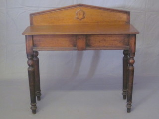 A Victorian oak hall table with raised back, fitted a drawer and raised on turned supports 36"
