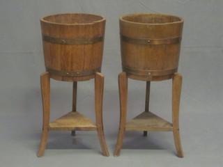 A pair of 1930's coopered oak jardiniere stands, raised on tapering supports with triangular shaped undertier