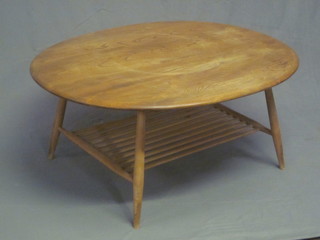 A 1970's Ercol light elm oval coffee table, the base incorporating  an undertier, raised on turned supports 39"