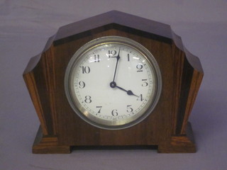 An Art Deco French 8 day bedroom timepiece with enamelled  dial and Arabic numerals contained in a shaped inlaid mahogany  case