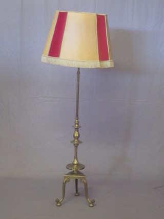 A brass adjustable standard lamp, with triform base, raised on 3  cabriole supports