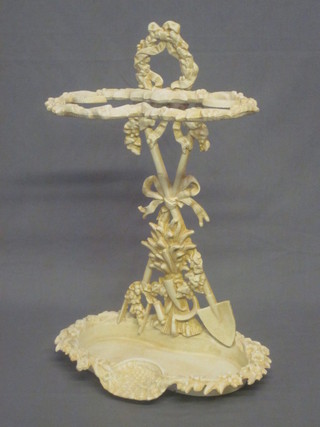 A white painted Victorian style cast iron umbrella stand decorated gardening trophies