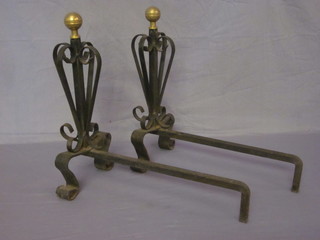 A pair of wrought and brass fire dogs