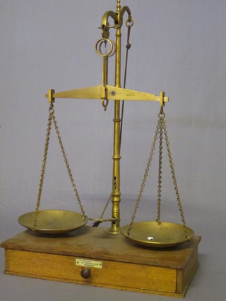 A pair of 19th Century brass pan scales, raised on a rectangular  oak base by L M Attwood