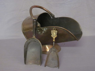A copper helmet shaped coal scuttle and 2 coal shovels