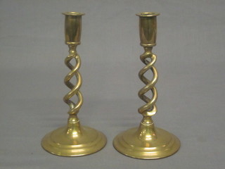 A pair of brass candlesticks raised on spiral turned columns 8"