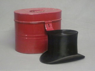 A gentleman's black silk top hat contained in a red painted  pressed metal hat box