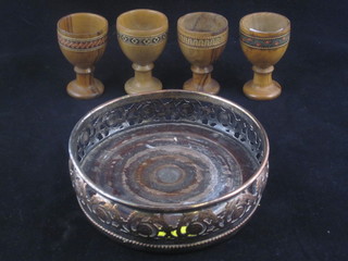 A pierced silver plated bottle coaster and 4 inlaid olive wood egg cups