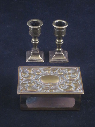 A pair of miniature brass taper sticks 2 1/2" and an embossed brass matchbox