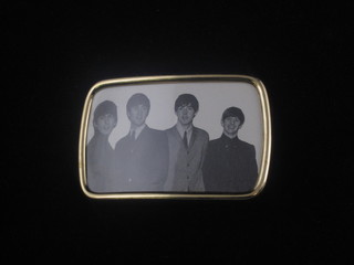 A gilt metal belt buckle decorated a photograph of the Four  Beatles