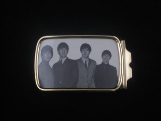 A gilt metal belt buckle decorated a photograph of the Four  Beatles