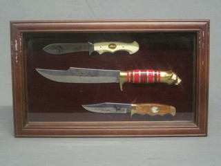 2 reproduction Bowie knives and a folding knife, contained in a glazed cabinet