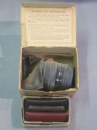 A WWII civilian gas mask together with a collection of old spectacles