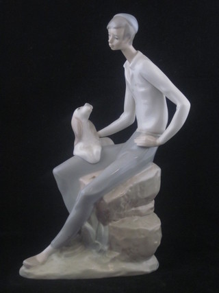 A Lladro figure of a seated gentleman with skull cap and puppy  10"