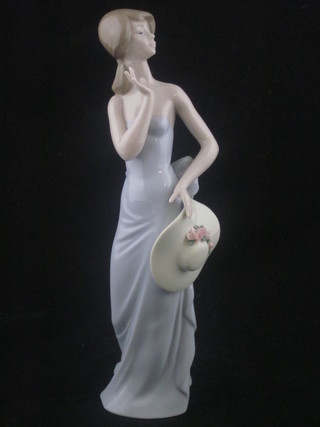 A Lladro figure of a standing lady with bonnet, base marked 5599 8"