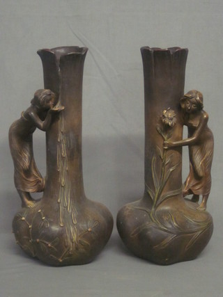 A pair of Art Nouveau style pottery vases decorated figures of standing girls with flowers 16"